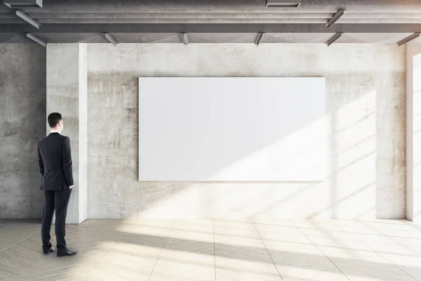 Geschäftsmann Blickt Auf Leeres Plakat Betonwand Galerie Und Präsentationskonzept Attrappe — Stockfoto