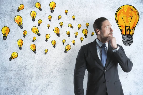 Businessman Drawing Yellow Lightbulbs Sketch Concrete Wall Success Startup Concept — Stock Photo, Image