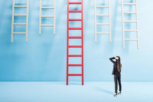 Joven Mujer Negocios Pie Interior Azul Mirando Escalera Roja Éxito — Foto de Stock