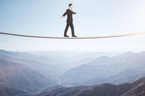 ビジネスマンは山の背景にロープを歩いている ビジネスと挑戦の概念 — ストック写真