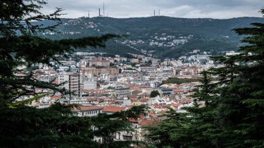 Ağaçların çerçevelediği Parco della Rimembranza 'dan Trieste şehir manzarası