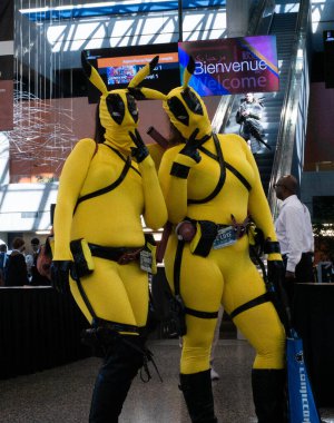 Montreal, Quebec, Kanada - 7 Temmuz 2019: Comiccon: Kostümcüler: Kameraya poz veren iki sevimli Pikachu-Deadpool kızı