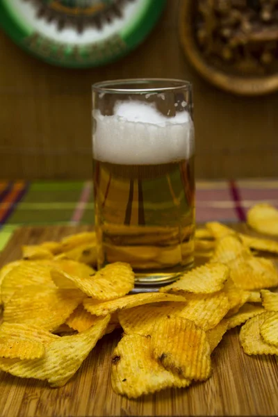 Beer in a glass with chips and breadcrumbs. In a glass goblet.