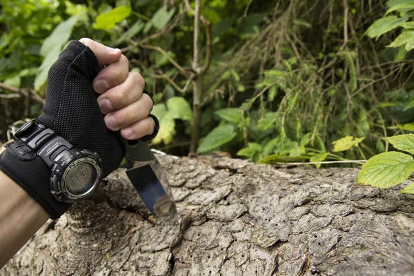 A gloved hand with a watch And a knife. knife in hand. Gloved hand.