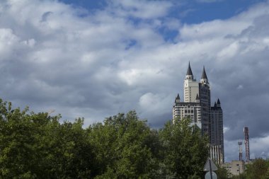 Yeşillikler arasında şehirde çok katlı bir ev. Yol işareti.