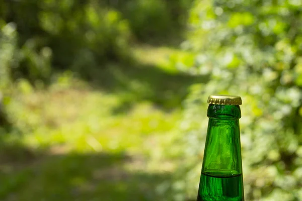 Glass transparent green glass bottle. With a cork and a bottle opener.