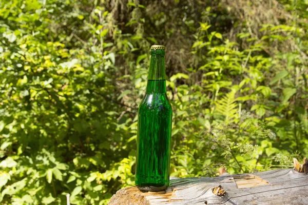 Glass transparent green glass bottle. With a cork and a bottle opener.