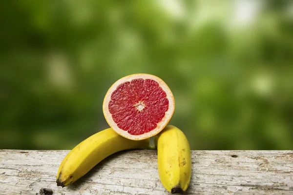 Bananer Och Grapefrukt Färgad Bakgrund Royaltyfria Stockfoton