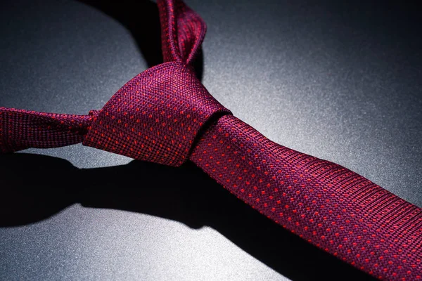 暗いテーブルの上に赤いネクタイを結ぶ. — ストック写真