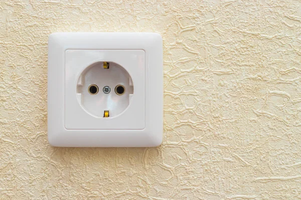 An electrical outlet on the wall in the office or apartment. Yellow background. — Stock Photo, Image