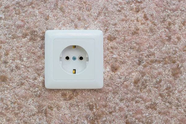 An electrical outlet on the wall in the office or apartment.
