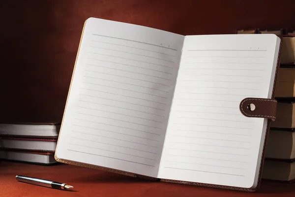 Een notebook met tekstboeken op een houten tafel. — Stockfoto