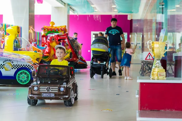男孩正骑着一辆小汽车穿过购物中心。切博克萨里， 俄罗斯， 2018/08/20 — 图库照片
