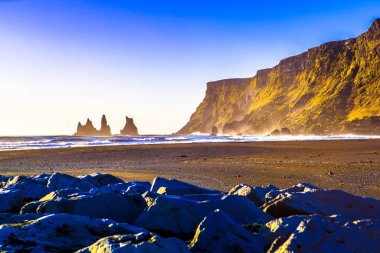 Reynisdrangar, dağ Reynisfjall eteklerinde bazalt deniz yığınları, iki trol efsanesi karaya üç direkli gemi sürükledi ve gün ışığı kırdı onlar kaya iğneleri oldu