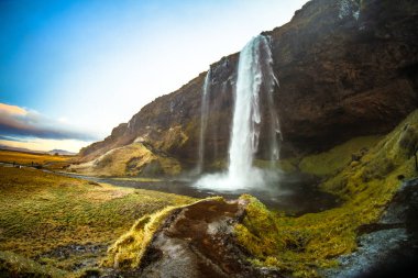 Seljalandsfoss, İzlanda güney bölgesinde arkasında küçük bir mağara ile bir şelale, bu yanardağ buzul Eyjafjallajokull kökeni olan Seljalands Nehri'nin bir parçasıdır