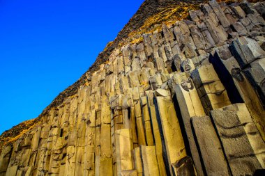 İzlanda güney kıyısında Reynisfjara (Reynisfjoru) plajda bazalt sütun ile Reynisfjall dağ.