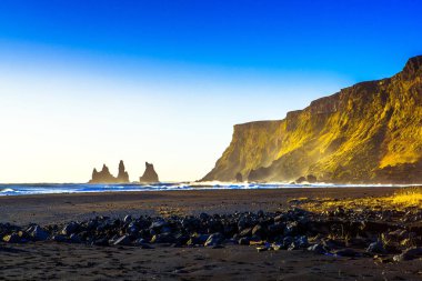 Reynisdrangar, dağ Reynisfjall eteklerinde bazalt deniz yığınları, iki trol efsanesi karaya üç direkli gemi sürükledi ve gün ışığı kırdı onlar kaya iğneleri oldu