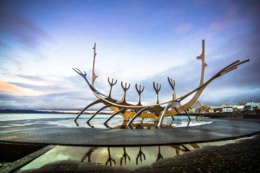 Reykjavik, İzlanda - 8 Kasım 2017 - Saebraut yolunun yanında yer alan alacakaranlık gökyüzüile Solfar'ın (Sun Voyager) sokak manzarası