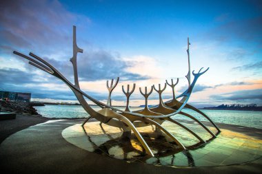 Reykjavik, İzlanda - 8 Kasım 2017 - Saebraut yolunun yanında yer alan alacakaranlık gökyüzüile Solfar'ın (Sun Voyager) sokak manzarası