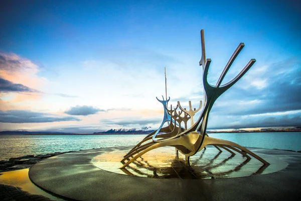 Reykjavik, İzlanda - 8 Kasım 2017 - Saebraut yolunun yanında yer alan alacakaranlık gökyüzüile Solfar'ın (Sun Voyager) sokak manzarası