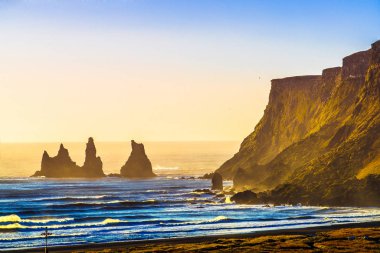 Reynisdrangar, dağ Reynisfjall eteklerinde bazalt deniz yığınları, iki trol efsanesi karaya üç direkli gemi sürükledi ve gün ışığı kırdı onlar kaya iğneleri oldu