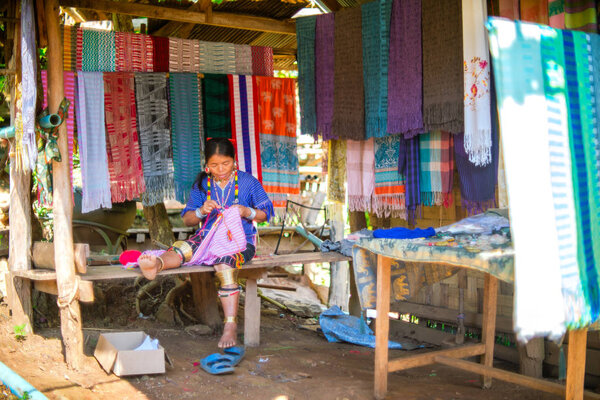 Mae Hong Son, Thailand - November 23, 2018 - Unidentified Karen woman weaving color fabric in Longneck Village (Kayan)