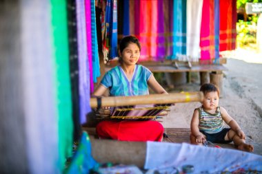 Mae Hong Son, Tayland - 23 Kasım 2018 - Longneck Village'da renkli kumaş ören kimliği belirsiz Karen kadın (Kayan)