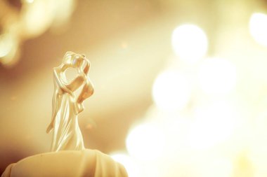 Gelin ve Damat düğün bebekleri arka planda avize ışık bokeh ile düğün pastası üzerine dekore