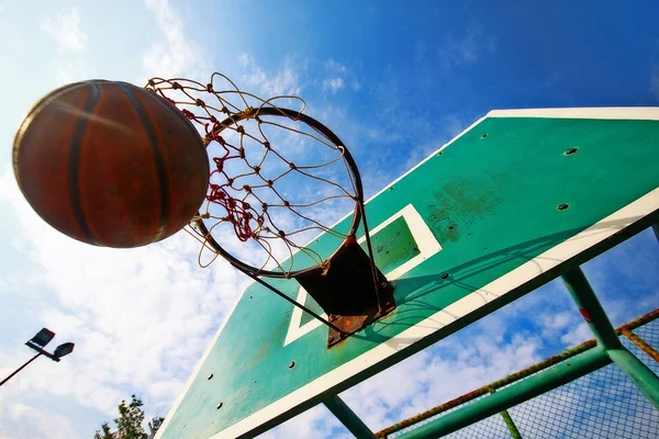 Basketball thrown in the hoop, scoring in game.