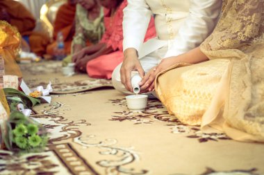 Chonburi, Tayland - 20 Kasım 2016 - Tayland kültürel nişan töreninin Budist liyakat in pirinç gemiden kutsal su döken gelin ve damat