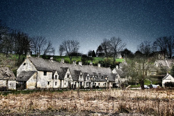 Stars field on night sky over cottages in rural town upon Avon, England