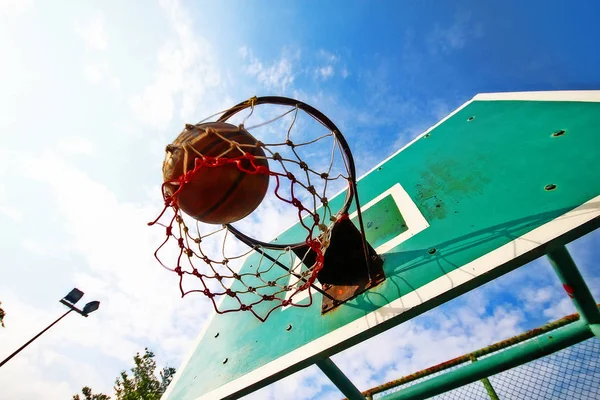 Basketball thrown in the hoop, scoring in game.