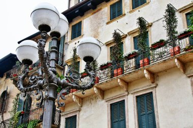 Verona, Veneto bölgesindeki geleneksel eski evin pencere ve balkonuna sahip sokak lambası, İtalya