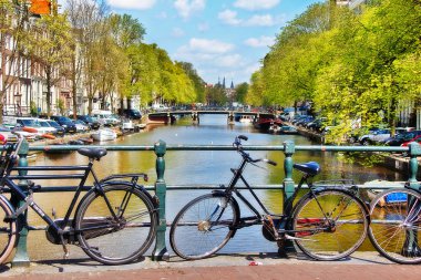 Amsterdam, Hollanda - 4 Mayıs 2016 - Amsterdam City, Canal ve yaya yolu üzerinde parkedilmiş bisikletlerin sahnesi.