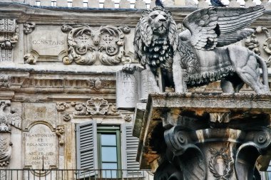 Veneto bölgesi, Verona, İtalya - 20 Mart 2010 - Venedik şehrinin sembolü olan Saint Mark heykelinin aslanı, Piazza delle Erbe 'de (Pazar Meydanı) eski bir binanın arka planında).