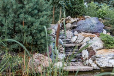 Göletin kıyısında taştan ve kamışlardan yapılmış yapay bir kaydırak.