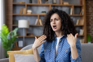 Evde sıcaklık vardı, bir kadın ellerini sallıyordu. Oturma odasındaki kanepede otururken dinlenmeye çalışıyordu. Bozuk ve çalışmayan bir klima vardı..