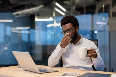 Bir kanepede astım krizi geçiren, nefes almaya çalışan ve göğsüne tutunan genç bir kadın, hemen yardım için mavi solunum cihazına uzandı.