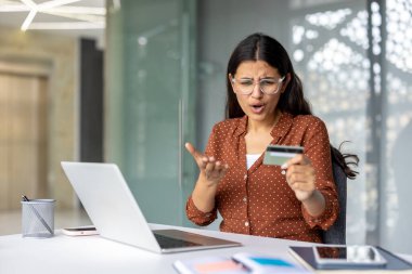 Hüsrana uğramış genç Hintli kadın elinde kredi kartı tutarken online alışveriş yapmaya çalışıyor, ödeme hatası ya da bilgisayarında işlem hatası ile karşı karşıya kalıyor.