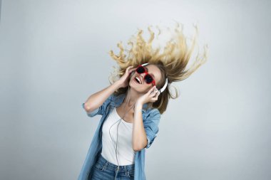 kulaklık ve güneş gözlüğü sarışın mutlu kadın hareket beyaz izole arka plan dans müzik dinlerken
