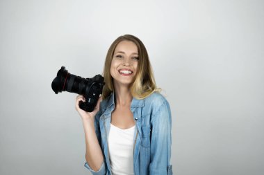 mutlu sarışın genç kadın elinde izole beyaz arka plan gülümseyerek fotokamera tutan