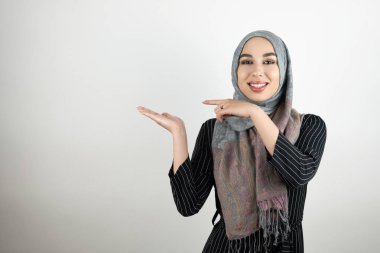 türbanlı türban takan genç müslüman öğrenci, parmağıyla yönünü ona doğru gösteren başka bir el hisolated beyaz arka plan