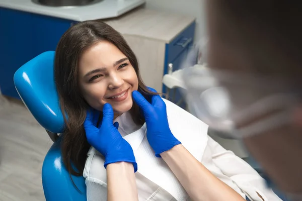Ung vacker kvinna patient och tandläkare i blå handskar medicinsk mask och skyddsglasögon ser nöjda nöjda med behandlingsresultat i Dental Clinic — Stockfoto