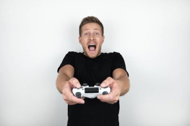 elinde joystick tutan siyah t-shirt giyen yakışıklı genç adam video oyunu oynar mutlu izole beyaz arka plan görünüyor