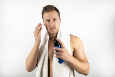 omuzlarında beyaz havlu ile genç adam onun sabah rutin izole beyaz arka plan yapıyor elinde tıraş köpüğü tutarak görüntü
