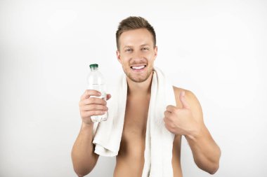 egzersiz beyaz arka plan sonra su şişesi tutarak omuzlarında beyaz havlu ile yakışıklı gülümseyen adam görüntü