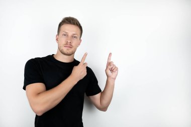 izole beyaz arka plan kadar parmaklarıyla işaret siyah t-shirt giyen yakışıklı genç adam