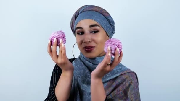 Joven hermosa mujer árabe sonriendo sosteniendo deliciosos cupcakes en ambas manos sobre fondo blanco aislado — Vídeo de stock