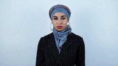 genç güzel arap kadın izole beyaz arka plan üzerinde hareket eden iki eliyle yakasını ayarlayarak gülümseyerek