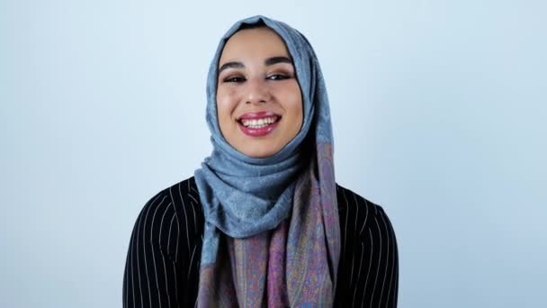 Joven hermosa mujer árabe riendo generosamente con la boca abierta sobre un fondo blanco aislado — Vídeos de Stock